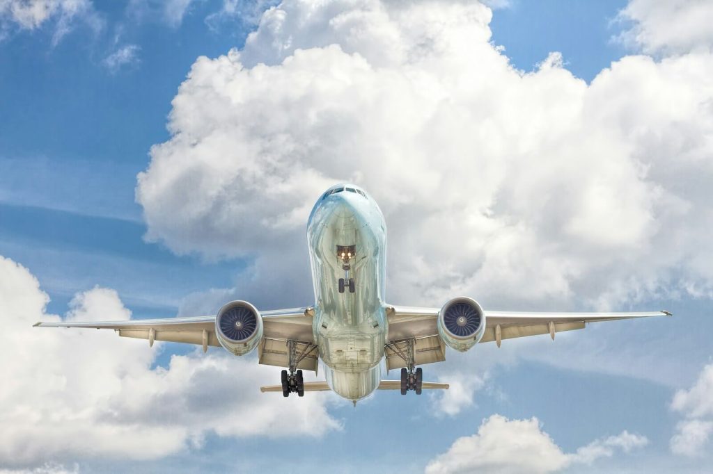 Airplane in flight against a blue sky with clouds