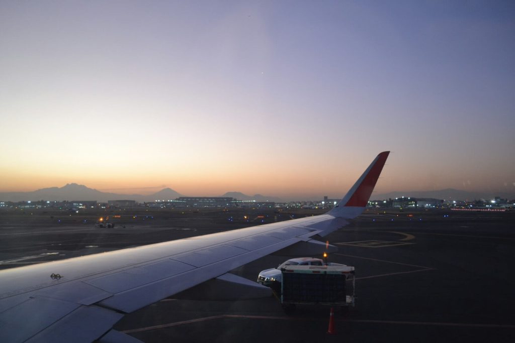 Alaska Atmos Rewards Summit Card Bonus: 80K Points & 25K-Point Global Companion Award 10 View of an airplane wing on the tarmac at sunset