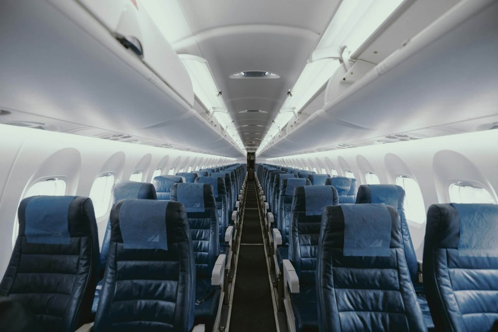 Empty airplane cabin with rows of blue seats
