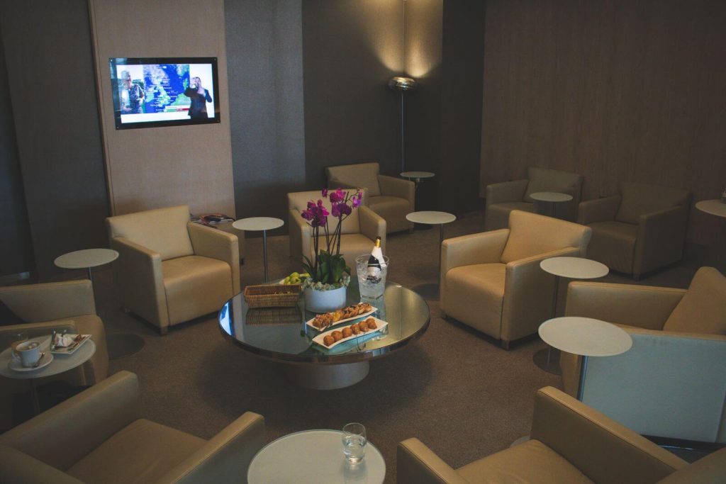 Premium airport lounge seating area with refreshments