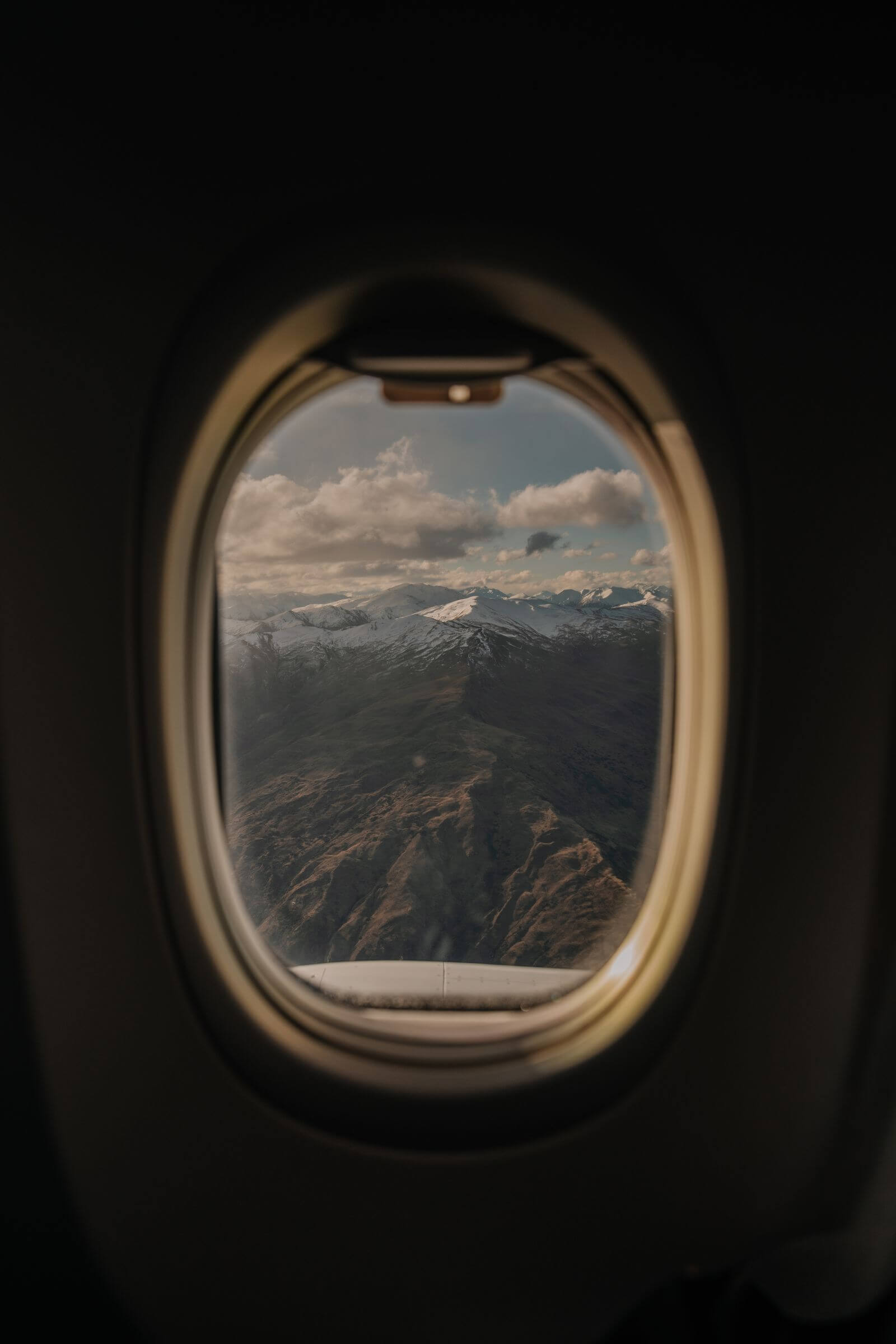 Snow-capped mountains seen through an airplane window