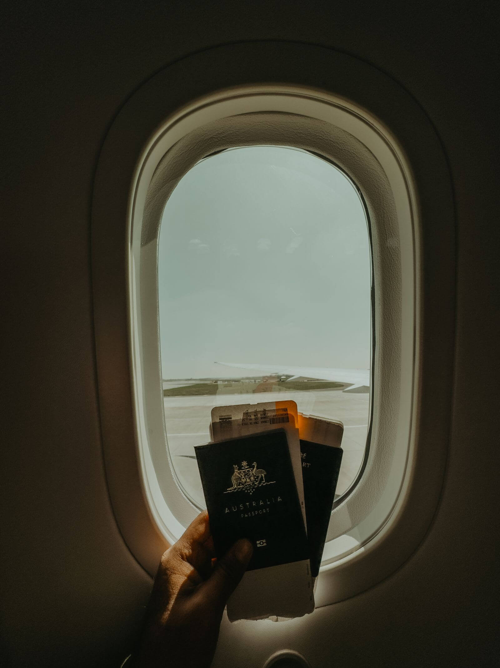 Codeshare Flights and Elite Status: Who Gets the Credit? 3 Passport and boarding passes held up to an airplane window