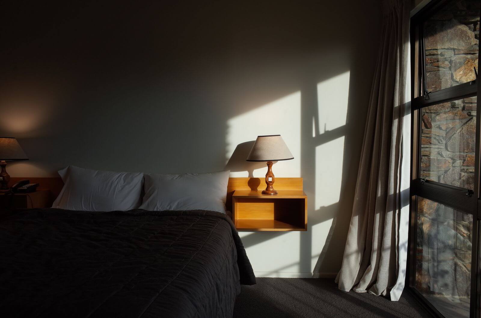 Hilton Amex Offer: Spend $200, Get 20,000 Bonus Points 4 Hotel room with bedside lamp and evening light